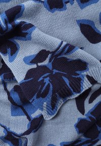 Tissu tricoté présentant un motif floral en bleu foncé et bleu clair sur un fond texturé doux ; couleur de base bleu pastel.