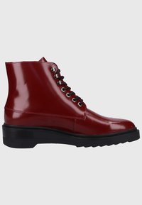 Red patent leather ankle boots with a smooth finish, black laces, silver eyelets, and a chunky black sole for added traction.