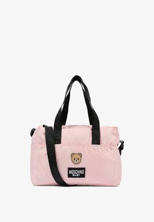 Jasnoróżowa pikowana torba z czarnymi paskami, z logo misia i etykietą "MOSCHINO BABY". Kompaktowy, prostokątny kształt.