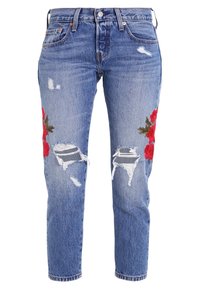 Ljusblå denimjeans med slitna detaljer, som har röd rosbroderi på varje ben. Rak benpassform med mellanhöjd på midjan.