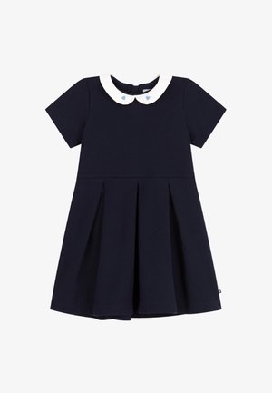 Navy zilā krāsa īsās piedurknes kleita ar baltu Peter Pan apkakli, kurā ir gaiši zili sirds akcenti. Šī kleita ir ar plīsušu svārku dizainu un izgatavota no mīksta auduma.