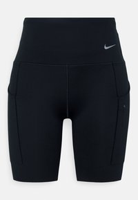 Shorts de sport noirs taille haute avec poches latérales et petit logo Nike swoosh réfléchissant sur la hanche gauche.