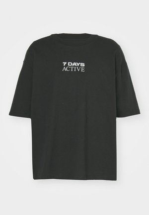 Zwarte katoenen T-shirt met een ontspannen pasvorm, geribbelde halslijn en korte mouwen. Bevat witte tekst "7 DAYS ACTIVE" op de voorkant.