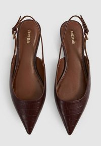 Slingback baleríny s špičatou špičkou z tmavě hnědé krokodýlí kůže s embossingem. Vyznačují se elegantním designem a nastavitelným popruhem se sponou. Viditelné logo značky.