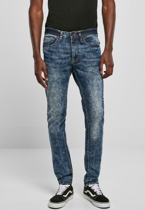 Jeans i lys og mørk blå med en falmet finish, med klassisk fem-lomme stil og rett benstil, båret med svarte sneakers.