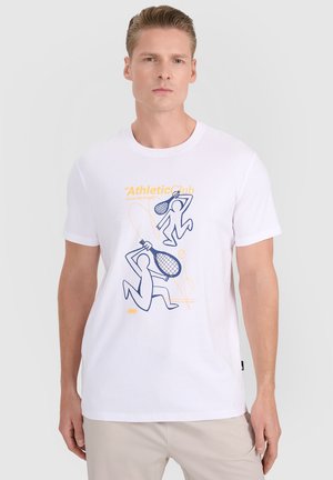 Mężczyzna w białej koszulce z niebiesko-pomarańczową grafiką przedstawiającą dwie abstrakcyjne postacie grające w tenisa oraz napisem "Athletic Club."