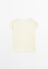 T-shirt à manches courtes en coton jaune pâle avec un col rond et une texture lisse. Présente un design simple et sans embellissement.