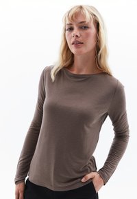 Lange mouwen shirt van lichtbruin stof, met een ronde halslijn en gestructureerde mouwen, nauwsluitende stijl en een gladde afwerking.