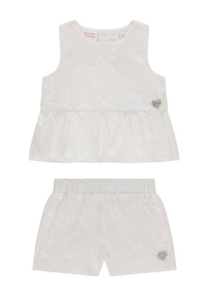 Weißes ärmelloses Oberteil mit Blumenstickerei und passende Shorts mit elastischem Bund, beide mit kleinen herzförmigen Metall-Logoschildern.