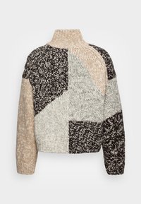 Suéter de punto con un cuello alto, que presenta un diseño de patchwork en beige, gris y negro. Hilo texturizado con puntos y patrones variados.