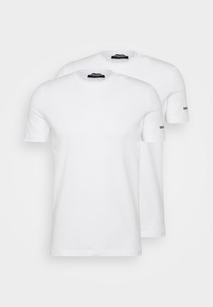 Deux T-shirts blancs en coton à manches courtes et col rond. Chacun a un petit logo noir sur la manche gauche. Texture lisse, coupe standard.