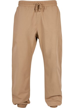 Beige színű jogger nadrág könnyű anyagból, rugalmas derékkal, állítható zsinórral és lefelé szűkülő mandzsettákkal a bokán.