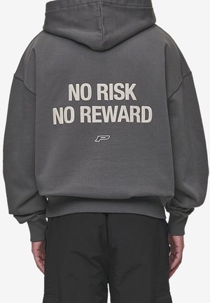 Sweat-shirt à capuche gris avec le texte "PAS DE RISQUE PAS DE RECOMPENSE" en blanc au dos. Coupe ample avec des poignets et un ourlet côtelés.