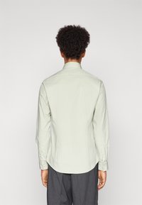 Lichtgroen overhemd met lange mouwen van een soepele stof, met een standaardkraag en knoopmanchetten, in een recht model gestyled.