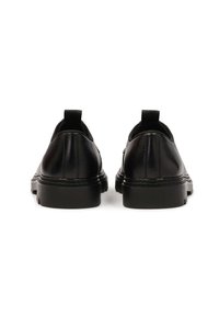 Zapatos de cuero negro con un acabado texturizado, punta redondeada, paneles laterales elásticos y una suela de goma negra, con tiradores en el talón.