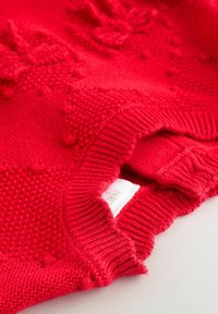 Rode gebreide trui met textuurpatronen en geribde kraag. Voorzien van een geweven label aan de binnenkant van de halslijn. Zacht, snug fit.