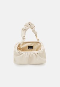 Krémová kabelka vyrobená z měkké tkaniny s zmačkanou rukojetí, zlatými kovovými detaily a vnitřní štítkem se značkou "PIECES."