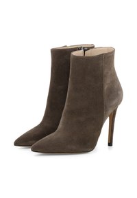 Bruine suède enkelbots met spitse neuzen en stiletto-hakken. Voorzien van een zijrits en een gladde binnenvoering.