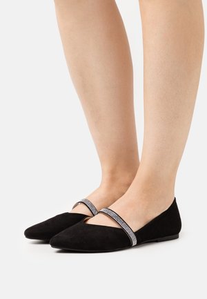 Black suede flats with a pointed toe and a thin, sparkling strap across the instep. The shoes have a flat sole and a smooth texture.