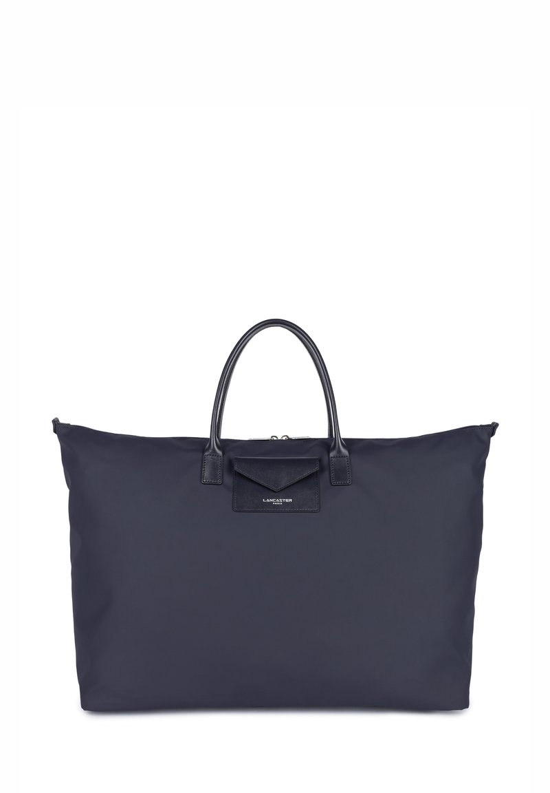 Borsa tote in nylon blu navy con doppio manico in pelle e tasca con pattina anteriore. Presenta una chiusura con zip e il logo del marchio. Texture liscia in tutto.