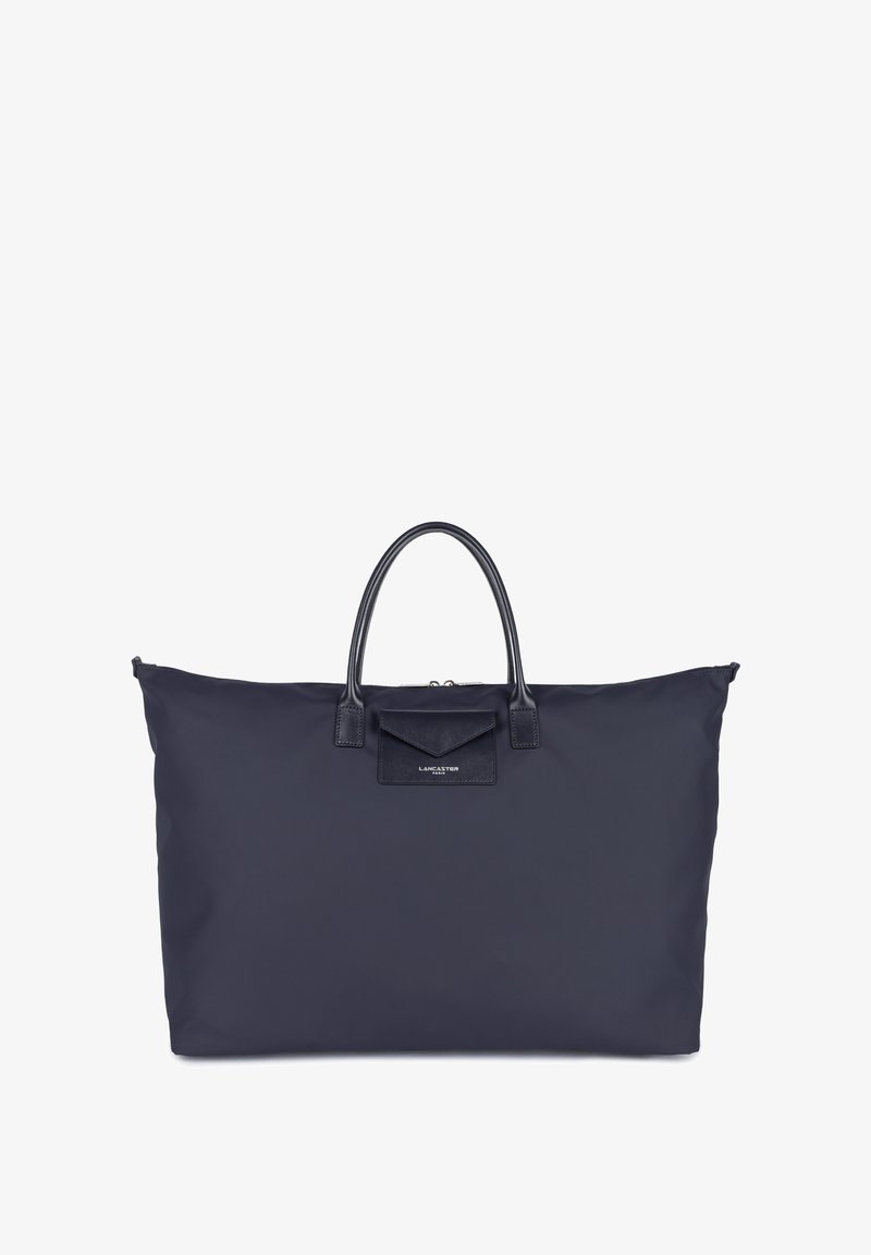 Borsa tote in nylon blu navy con doppio manico in pelle e tasca con pattina anteriore. Presenta una chiusura con zip e il logo del marchio. Texture liscia in tutto.