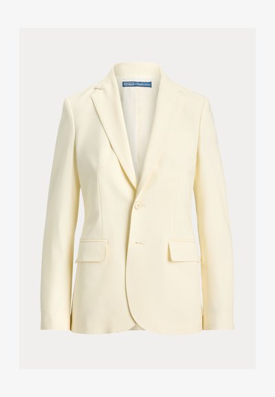 Krém színű egysoros zakó bevágott hajtókával, zsebfedős zsebekkel és Polo Ralph Lauren címkével a gallér belsejében.