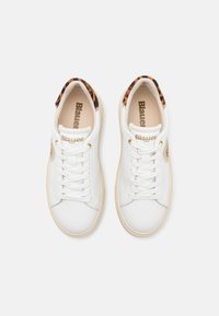 Sneakers in pelle bianca con suole in gomma beige, caratterizzati da accenti dorati e un motivo leopardato sul tallone. Design con lacci.