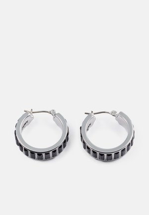 Boucles d'oreilles en argent en forme de créoles avec un accent noir côtelé autour du périmètre, dotées d'une fermeture à fermoir sécurisée et d'une finition lisse.
