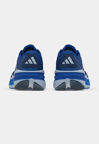 Sinised spordijalatsid, millel on tekstureeritud pealmine osa, hallid detailid ja vastupidav pehmendus. Kontsal on eristuv kolmetriibuline bränd.