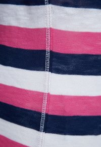 Tissu rayé avec des bandes horizontales de bleu marine, rose et blanc ; texture douce avec des coutures visibles le long de la couture.