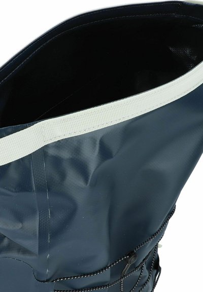 Sac étanche de couleur marine avec un revêtement texturé, une grande ouverture avec une bordure blanche et un cordon de serrage pour la fermeture.
