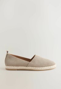 Beige espadril dengan bahan suede yang memiliki sol tali jute, dilengkapi dengan desain slip-on dan tekstur yang halus.
