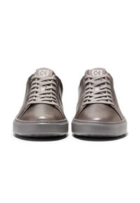 Šedé kožené tenisky s hladkým povrchem, kulatou špičkou, plochými tkaničkami a polstrovanou podrážkou. Na jazyku je decentní logo.