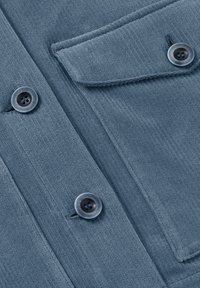 Modrá texturovaná látka s vertikálními pruhy, obsahující dva kulaté knoflíky a detaily s klopovým kapsou. Měkký, mírně elastický materiál.