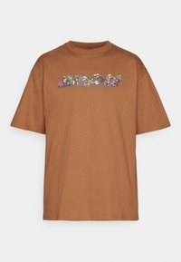 Brun bomull t-shirt med rundad halsringning och korta ärmar. Har färgglad blommig broderi över bröstområdet.