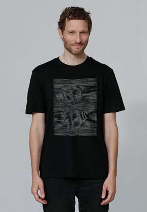 Zwart t-shirt van katoen met een grafisch ontwerp van een hand, gemaakt met horizontale witte lijnen. Korte mouwen en een ronde hals.