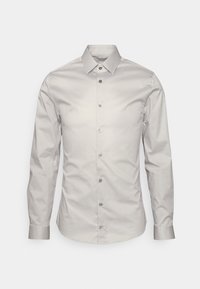 Camisa abotonada de color gris claro, hecha de un tejido suave, con cuello clásico, mangas largas y seis botones en la parte delantera.