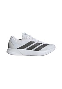 Weiße Sportschuhe mit einer strukturierten Oberfläche, die drei schwarze Streifen an den Seiten und eine leichte Gummisohle aufweisen.