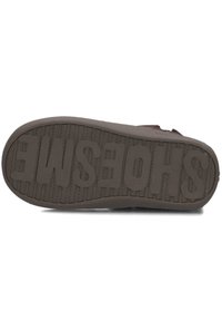 Bruine rubberen schoenzool met een getextureerde grip. Bevat in grote letters reliëf 'SCHOENEN', evenals een patroon aan de onderkant voor tractie.
