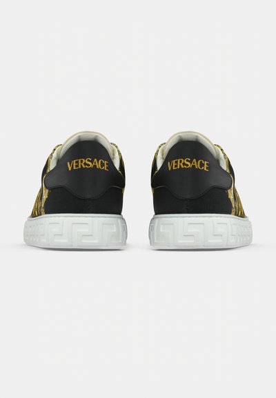 Juodi sportbačiai su geltonu „Versace“ logotipu, raštuotu tekstiliniu viršumi, baltu guminiu padu su graikų rakto raštu ir paminkštu apykakle.