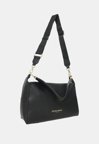 Sac à main en cuir noir avec une finition texturée, doté d'une poignée supérieure et d'une bandoulière amovible. Accents de logo dorés sur le devant.