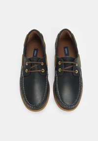 Zwarte leren schoenen met een ronde neus, tan accenten en bruine veters. Voorzien van contrasterende stiksels en een rubberen zool. Standaard ontwerp.