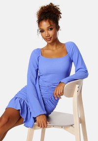 Geribbelde lavendel mini-jurk met lange klokmouwen en ruches aan de zijkanten, met een vierkante halslijn en een gerimpelde zoom.