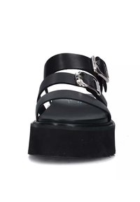 Sandali platform neri con molteplici sottili cinturini in pelle, dettagli in metallo argentato e una soletta nera texture. Il design mette in risalto un'estetica moderna.