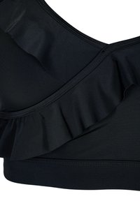 Sort sportsbh lavet af et struktureret stof, med en flæse design langsUDringning og en glat elastik forneden for støtte.