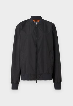 Fekete bomberdzseki, könnyű nylonból készült, cipzáros záródással és bordás mandzsettával. Simasága mellett oldalsó zsebekkel és kontrasztos bélésével rendelkezik.