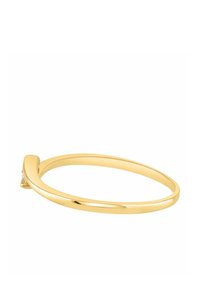 Zlatý prsteň s hladkým, okrúhlym obvodom, ktorý má na jednej strane mierne zatočenie a malý diamantový akcent blízko horného okraja.