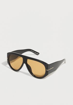 Schwarze, übergroße Sonnenbrille mit dicken Rahmen und bernsteinfarben getönten Gläsern, mit dezenten goldenen Details an den Bügeln.