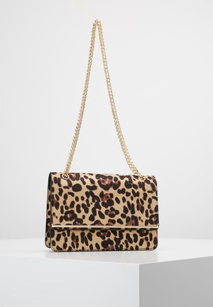 Torebka na ramię w panterkę z złotym łańcuszkiem i metalowym akcentem, o prostokątnym kształcie, prezentowana na białym podeście.