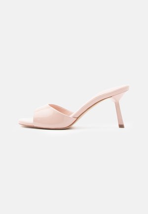 Mule con tacco aperte in vernice rosa, con tacco sottile e finitura liscia e lucida. Presentano una silhouette semplice e un design minimalista.